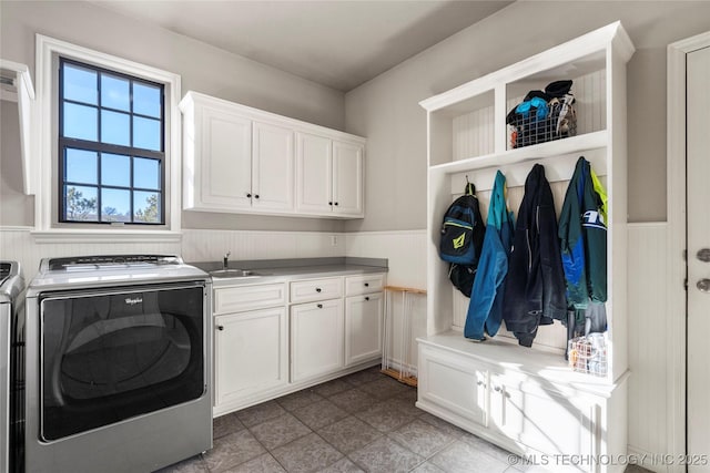 washroom featuring cabinet space, independent washer and dryer, and wainscoting