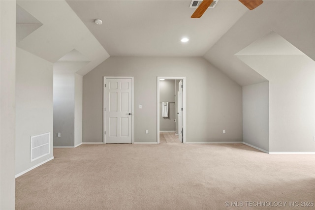 bonus room featuring lofted ceiling, baseboards, visible vents, and light colored carpet