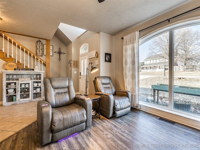 living area with wood finished floors, visible vents, and a healthy amount of sunlight