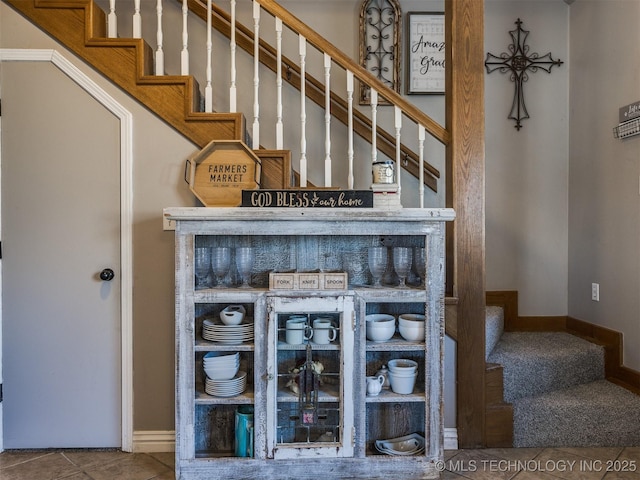 staircase featuring baseboards and tile patterned floors