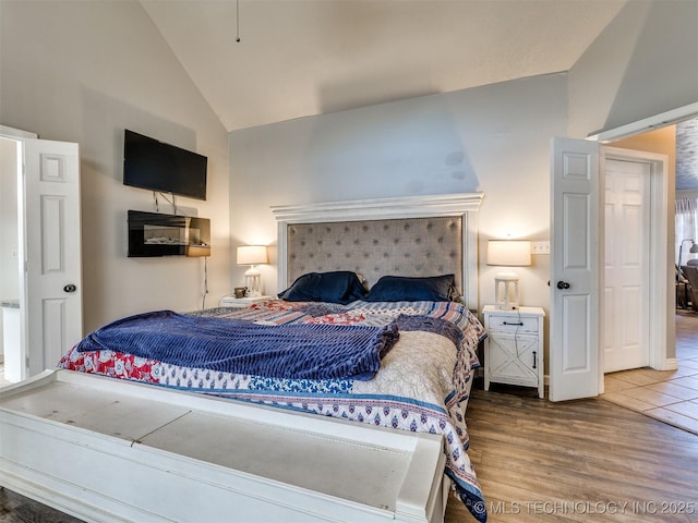 bedroom with vaulted ceiling and wood finished floors