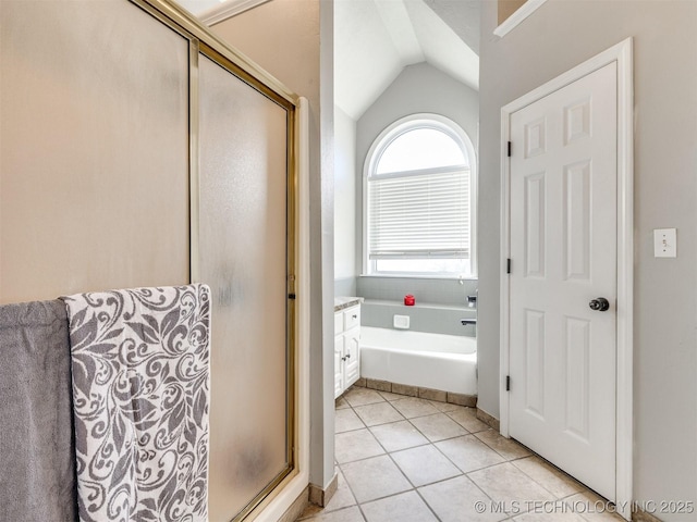 full bathroom featuring lofted ceiling, a stall shower, a garden tub, and tile patterned floors