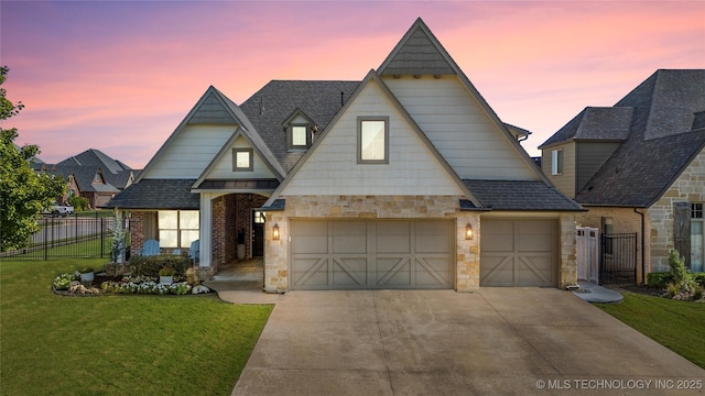 view of front of property featuring concrete driveway, stone siding, roof with shingles, fence, and a front lawn