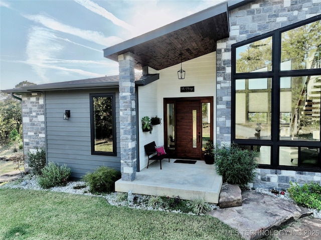 entrance to property with stone siding and a porch