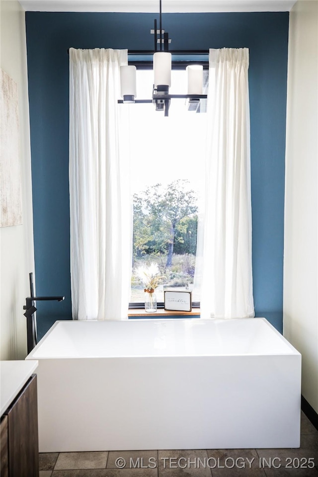 room details with a freestanding tub and an inviting chandelier