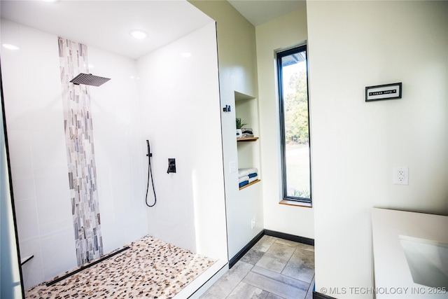 full bath featuring baseboards and tiled shower