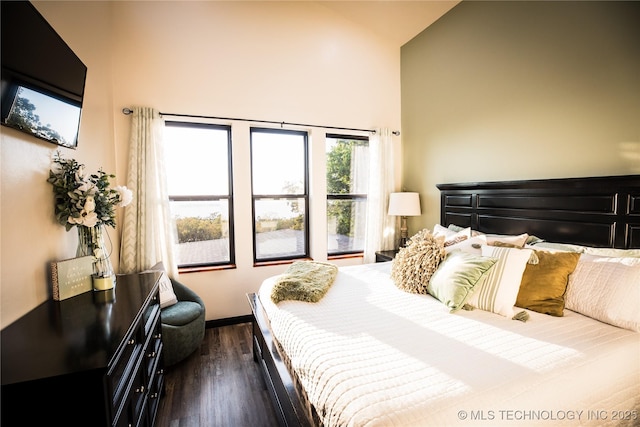 bedroom featuring high vaulted ceiling and dark wood finished floors