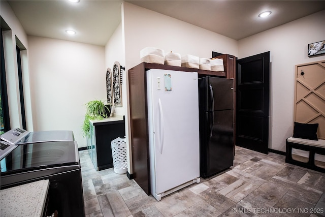 kitchen featuring baseboards, recessed lighting, freestanding refrigerator, and washer and dryer