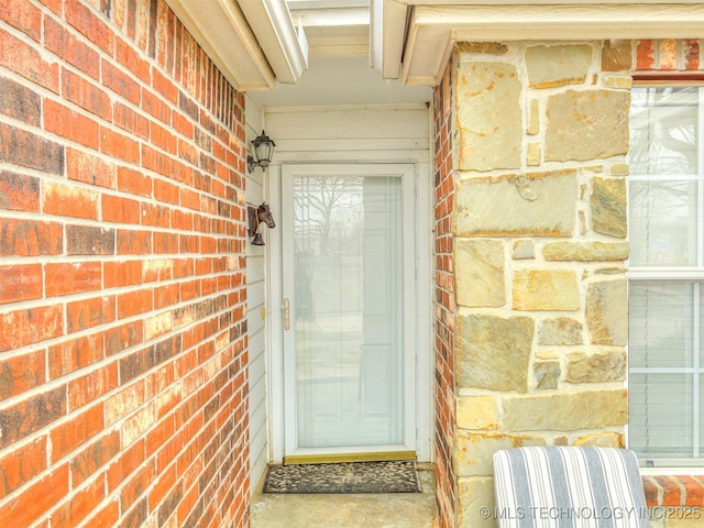 property entrance featuring brick siding