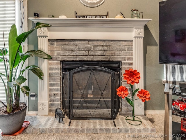 room details featuring a brick fireplace and a textured wall