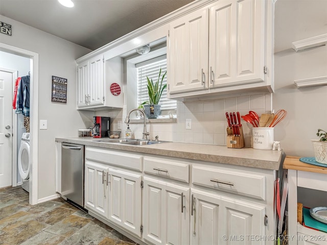 kitchen with tasteful backsplash, white cabinetry, light countertops, and a sink