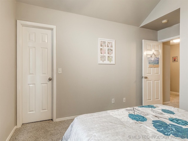 bedroom with light carpet, vaulted ceiling, and baseboards