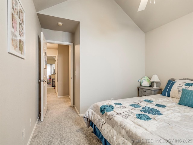 bedroom with a ceiling fan, light carpet, vaulted ceiling, and baseboards