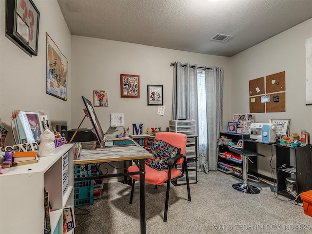 carpeted home office with a textured ceiling and visible vents