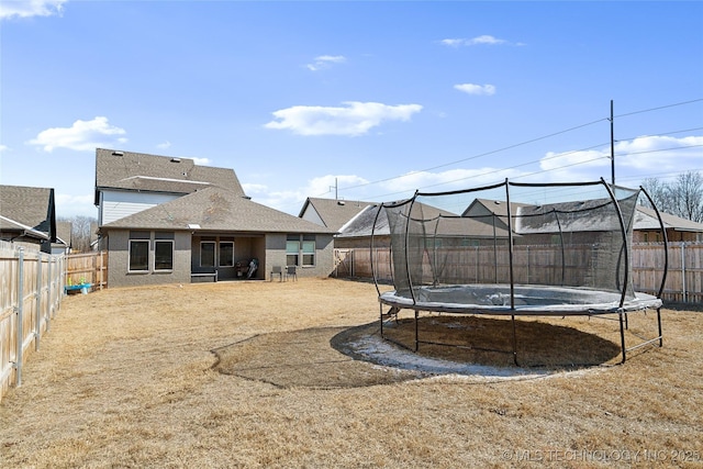 view of yard with a fenced backyard and a trampoline