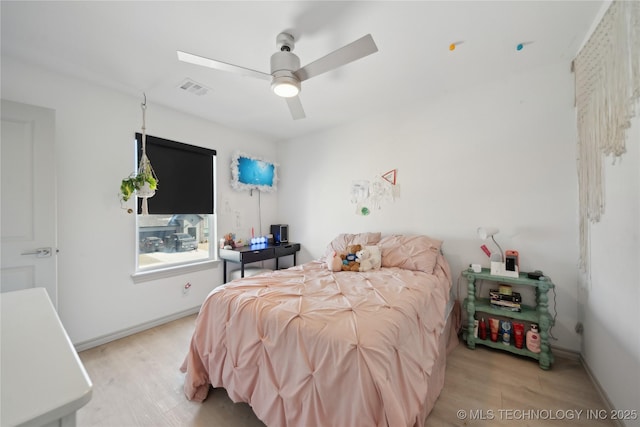 bedroom with light wood-style floors, baseboards, visible vents, and a ceiling fan