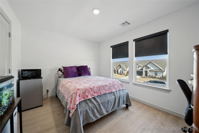 bedroom featuring light wood-style flooring and visible vents