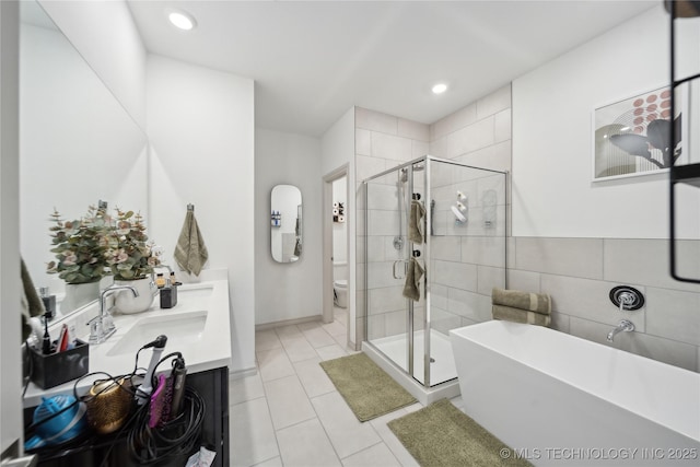 bathroom with toilet, a stall shower, a freestanding tub, and a sink