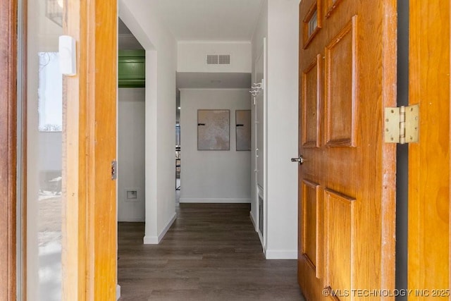 hall featuring dark wood-style floors, visible vents, and baseboards