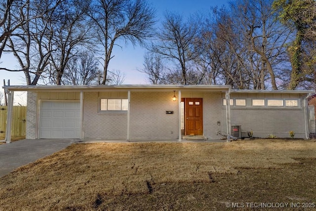 mid-century home with driveway, brick siding, central AC, and a front yard