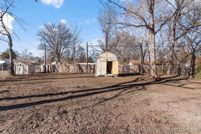 view of yard featuring an outbuilding, a storage shed, and fence