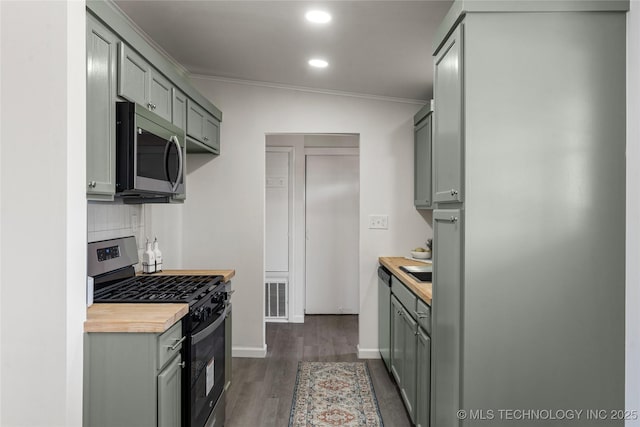 kitchen featuring visible vents, decorative backsplash, gray cabinets, stainless steel appliances, and dark wood-style flooring