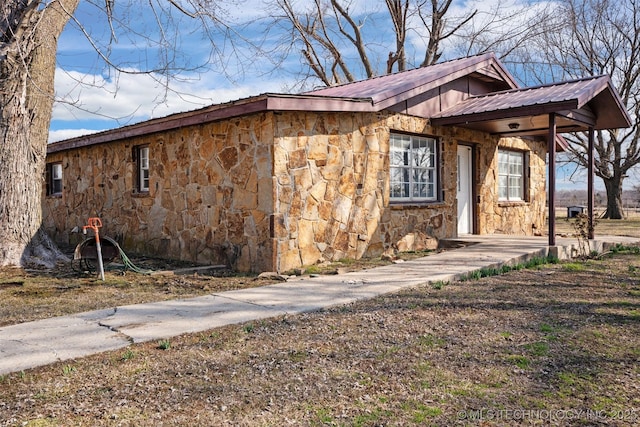 exterior space with stone siding and metal roof