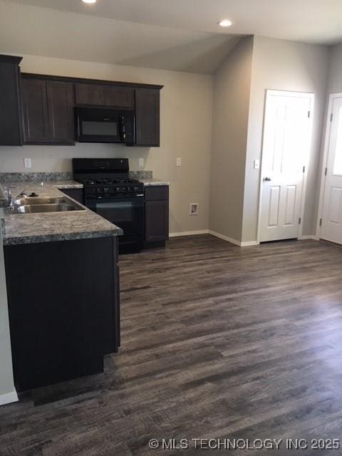 kitchen with black appliances, baseboards, dark wood-style flooring, and a sink