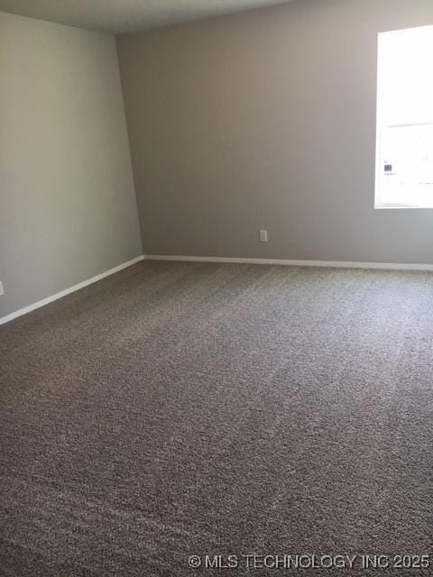 carpeted empty room featuring baseboards