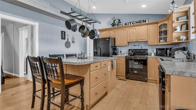 36953 US Highway 70, Bennington, OK 74723 - kitchen with black appliances, light brown cabinets, a sink, a breakfast bar, and light countertops