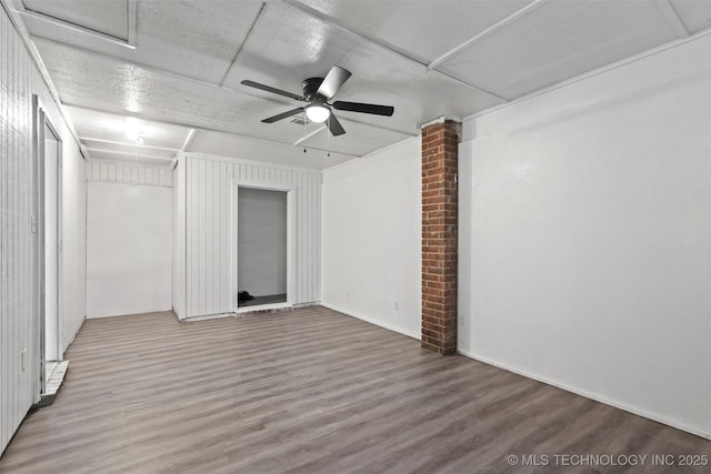 unfurnished room featuring a ceiling fan, decorative columns, and wood finished floors