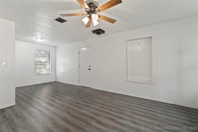 unfurnished room featuring dark wood-style floors, ceiling fan, a textured ceiling, and visible vents