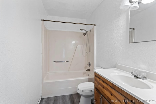 full bath with a textured wall, toilet, tub / shower combination, vanity, and wood finished floors