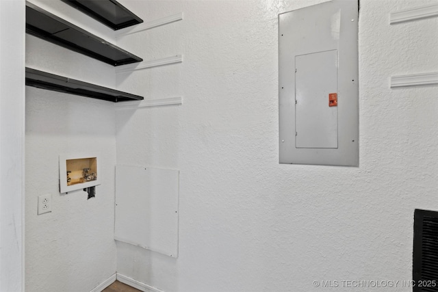 laundry area with hookup for a washing machine, laundry area, electric panel, and a textured wall