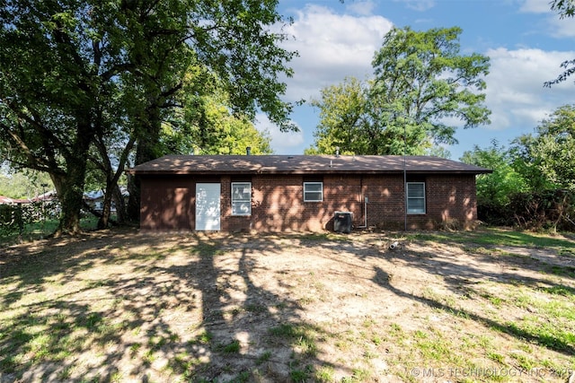 exterior space with brick siding and central AC