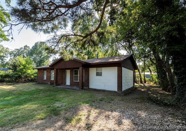 exterior space featuring driveway, a front yard, and brick siding