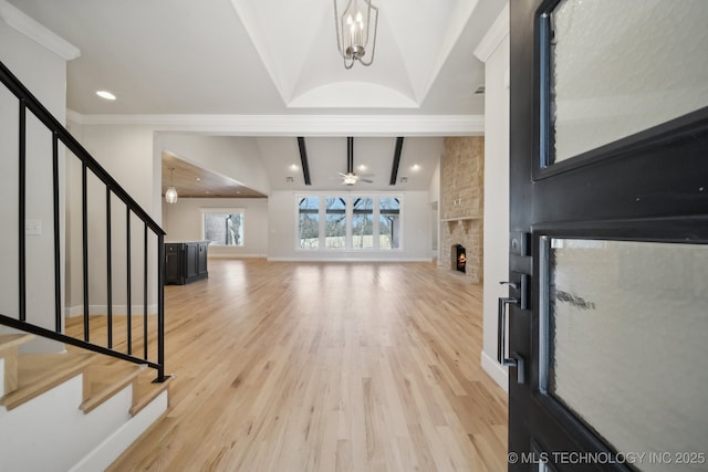 entryway featuring vaulted ceiling with beams, a stone fireplace, baseboards, stairs, and light wood-style floors