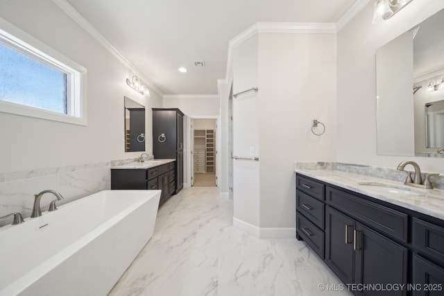 full bath with marble finish floor, a freestanding bath, ornamental molding, and a sink