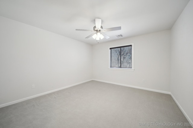 carpeted empty room featuring baseboards, visible vents, and a ceiling fan