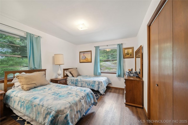 bedroom featuring a closet, baseboards, and wood finished floors