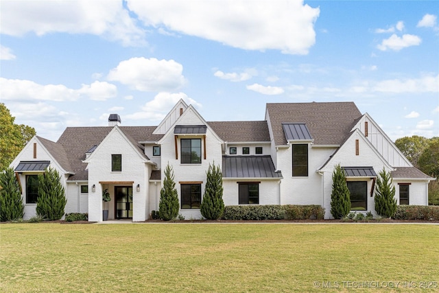 view of front of house featuring a standing seam roof, metal roof, a chimney, and a front lawn