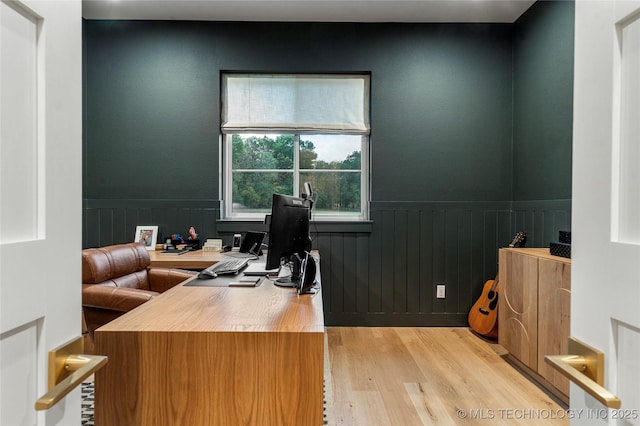 home office featuring wood finished floors and wainscoting