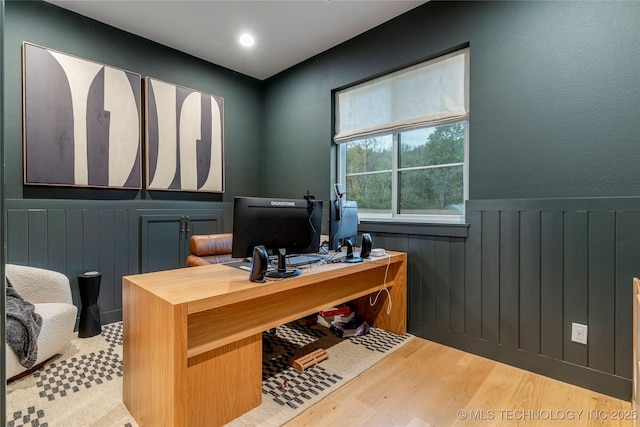 home office with wainscoting and wood finished floors