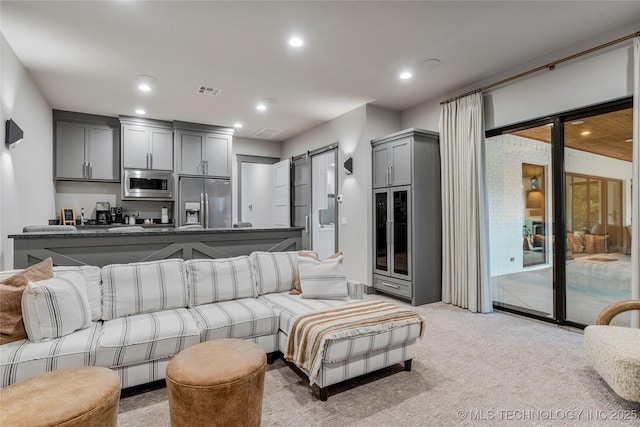 living room featuring light carpet, visible vents, and recessed lighting