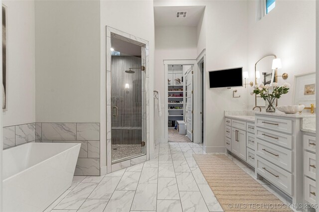 full bathroom with double vanity, visible vents, a soaking tub, marble finish floor, and a shower stall