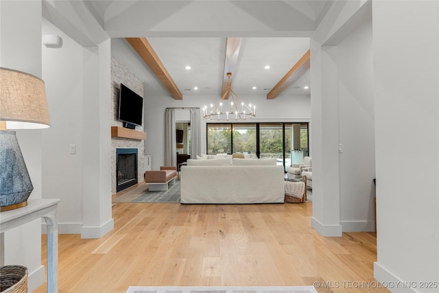 living area featuring a fireplace, a chandelier, light wood-type flooring, beamed ceiling, and baseboards