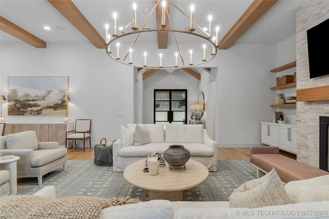 living room featuring light wood finished floors, a stone fireplace, beam ceiling, and baseboards