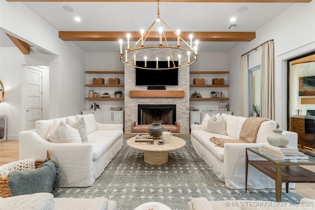 living room with a notable chandelier, a fireplace, wood finished floors, visible vents, and beam ceiling