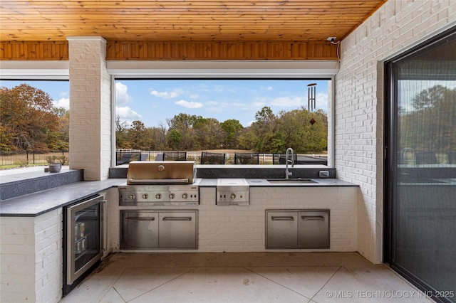 view of patio with wine cooler, area for grilling, a grill, and a sink