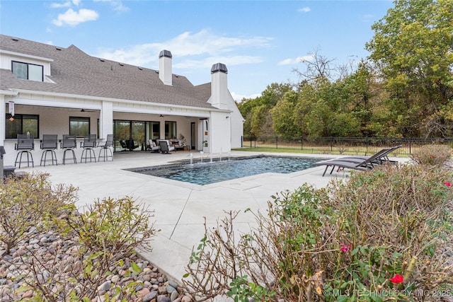 view of pool featuring ceiling fan, fence, outdoor dry bar, a fenced in pool, and a patio area